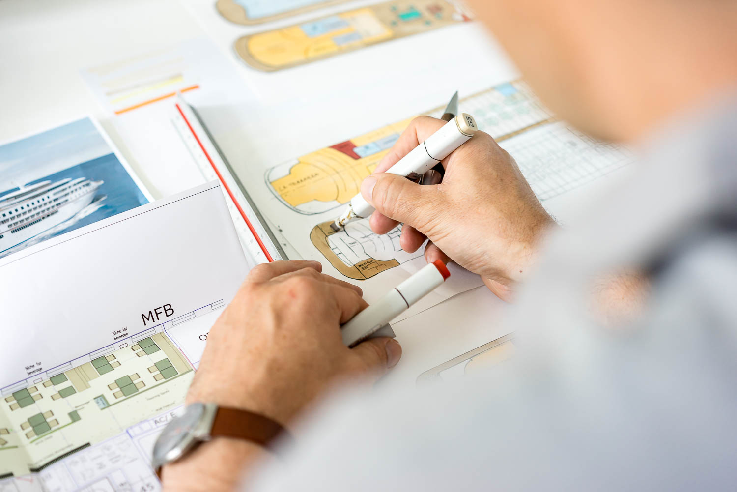Architekt zeichnet Decksplan eines Kreuzfahrtschiffs
